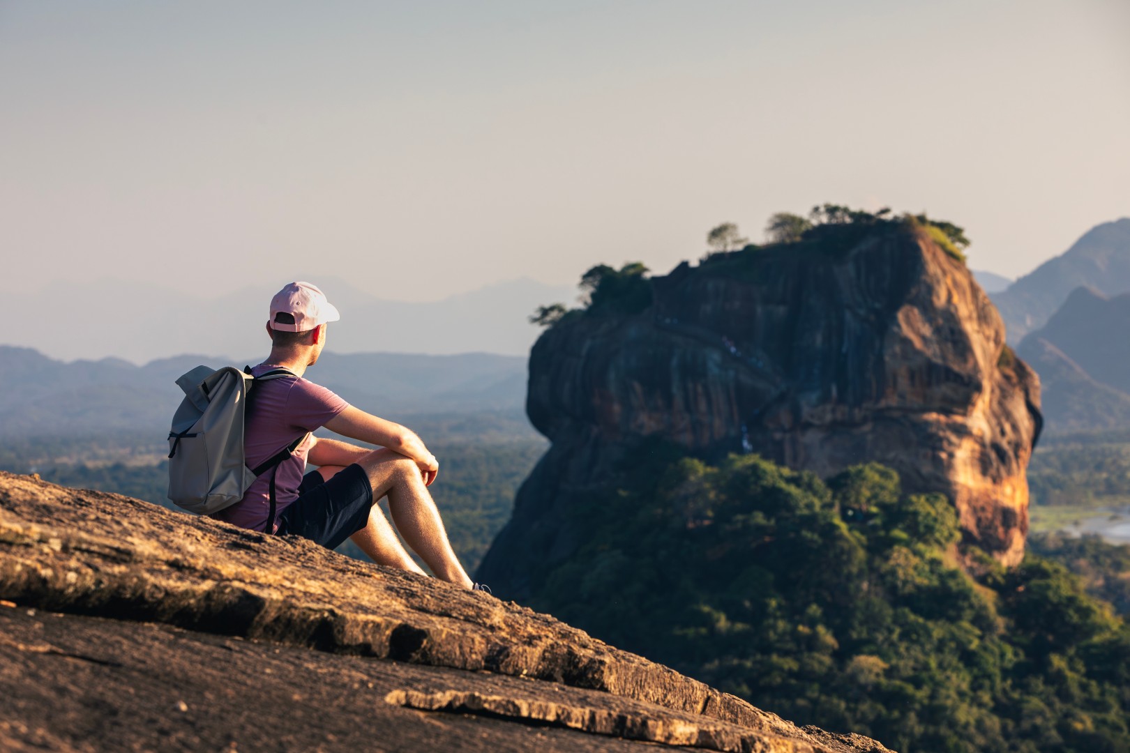 Man,With,Backpack,Sitting,On,Rock,And,Looking,At,Landscape